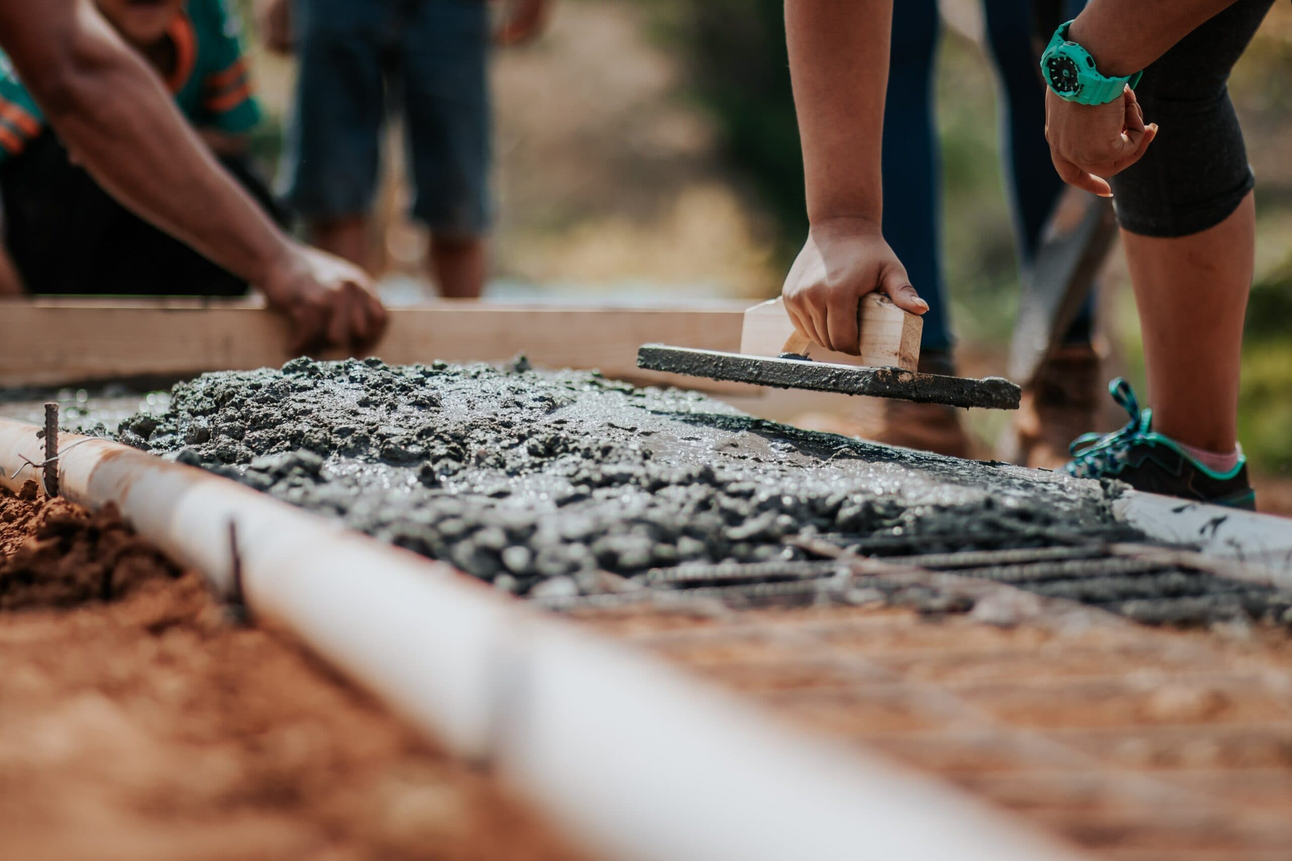 Volunteers spreading concrete on a community building project